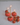 Ceramic Tomato Candle Holders with taper candles, styled with fresh tomatoes for a charming dining setting. Echoing Loewe's playful aesthetic.
